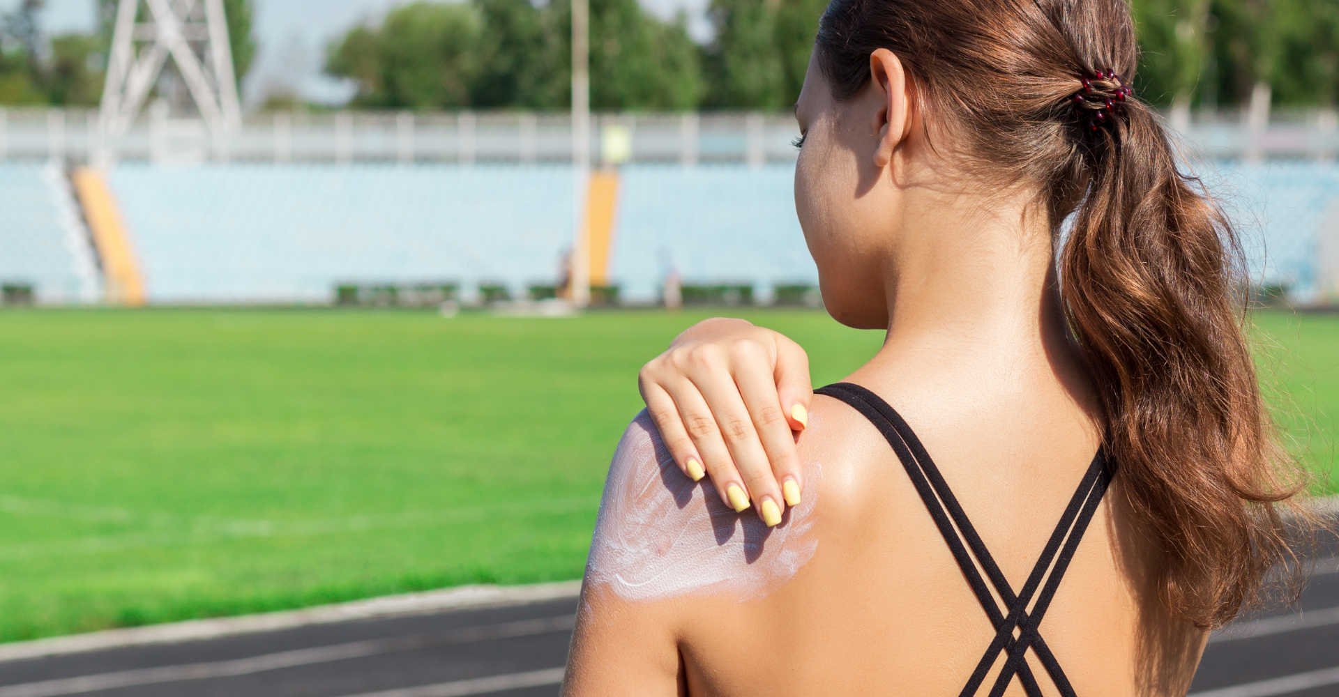 Modelo de costas passando protetor solar